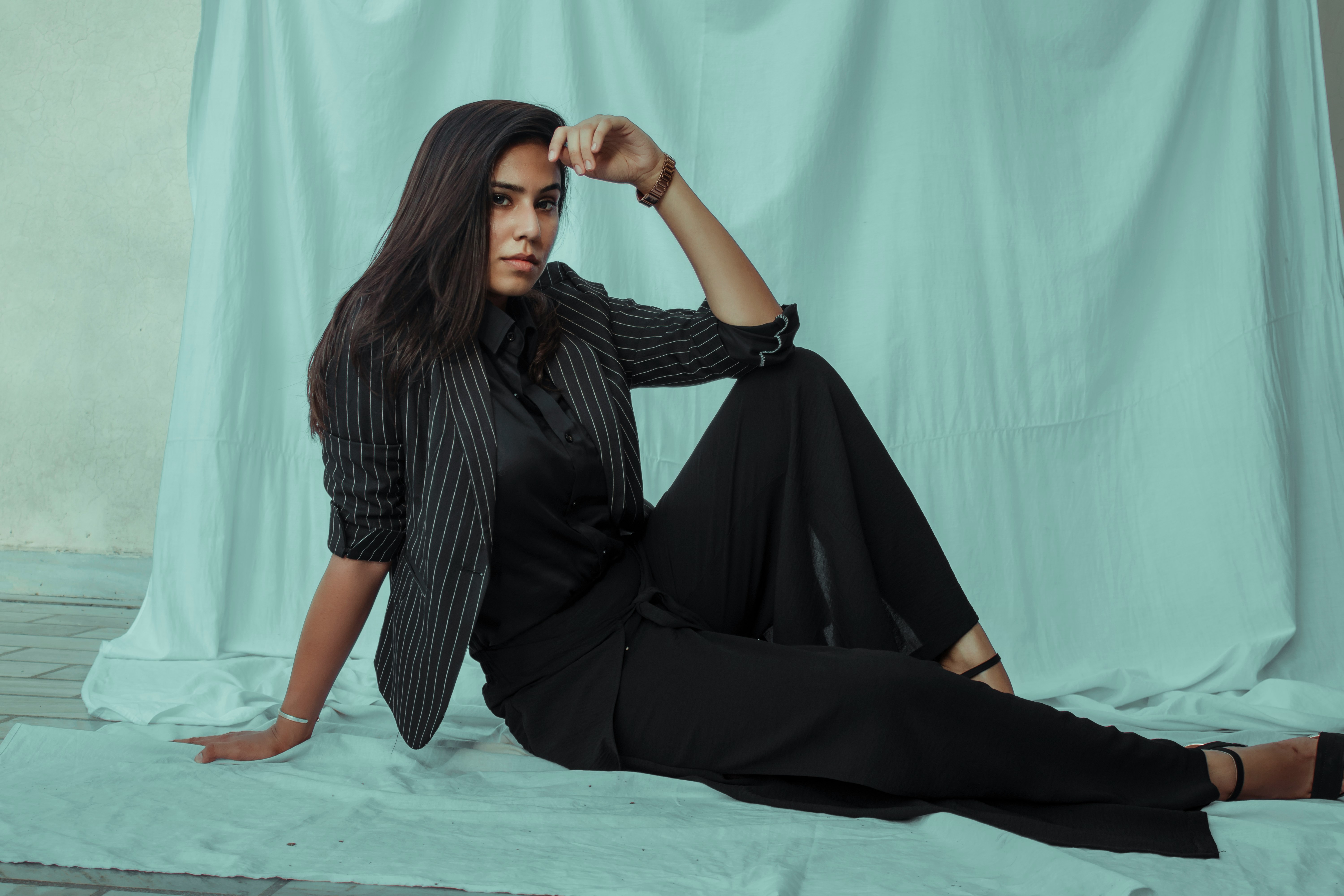 woman in black dress sitting on blue floor